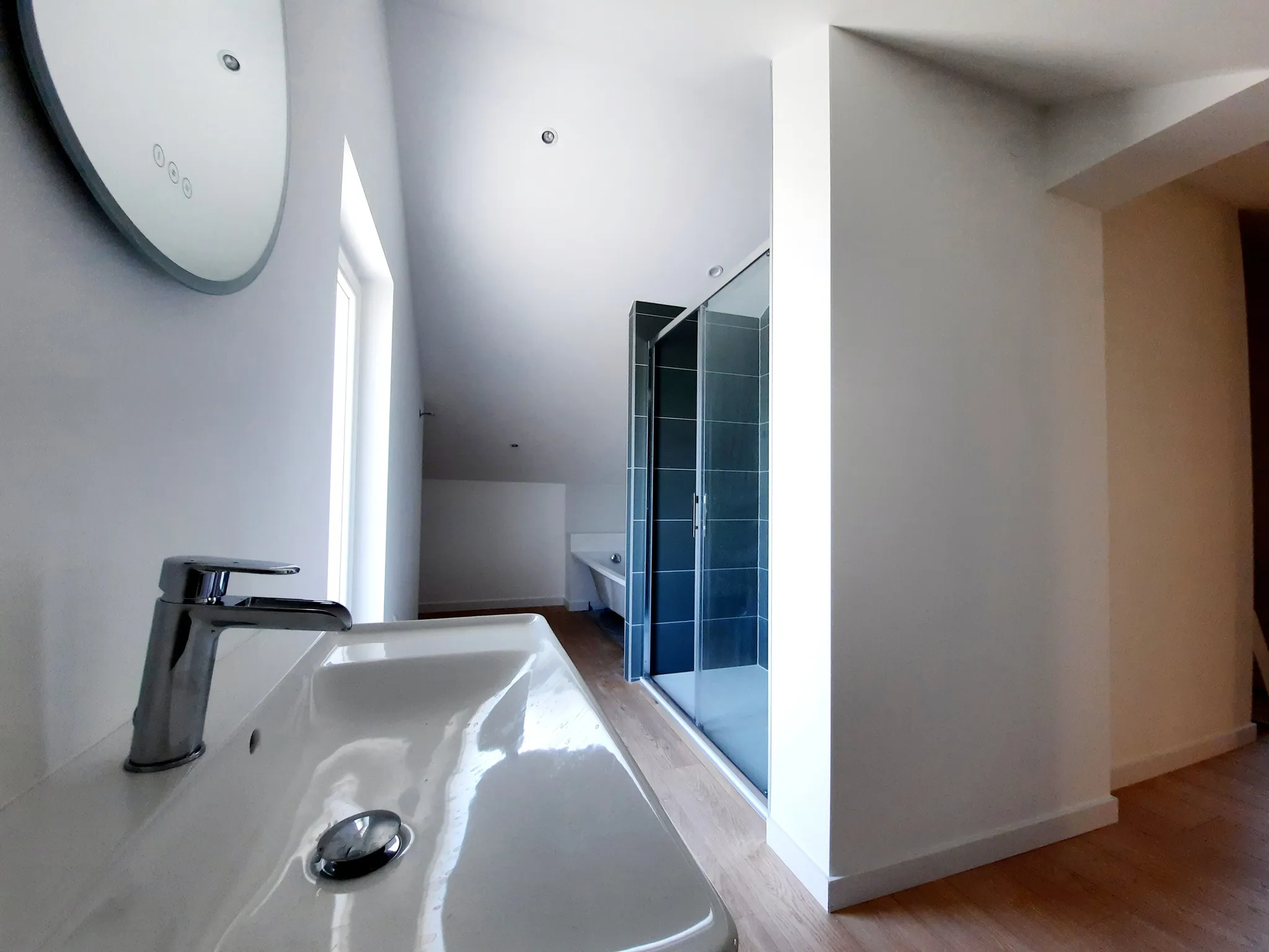 Salle de bain rénovée sous combles, plan vasque et douche carrelée